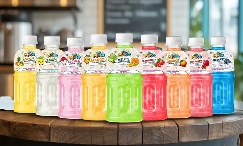 A colorful lineup of Mr. Moco nata de coco juice drinks displayed on a wooden table.