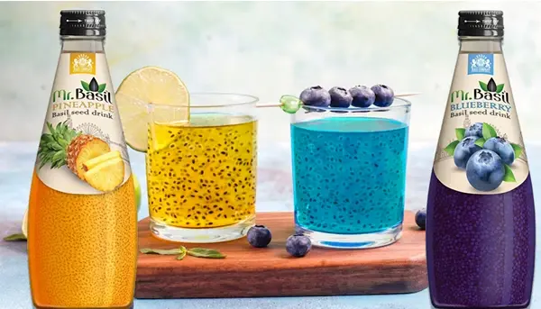 Mr. Basil Pineapple and Blueberry basil seed drinks with fresh fruit garnish in clear glasses.